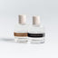 Two perfume bottles with labels on a light gray background